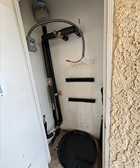 Plumbing team member organizing tools on truck shelves before heading to job