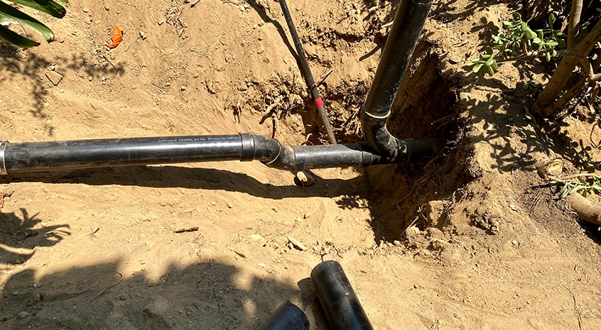 Blue plumbing banner with illustrated pipes and faucet icons spelling plumbing service