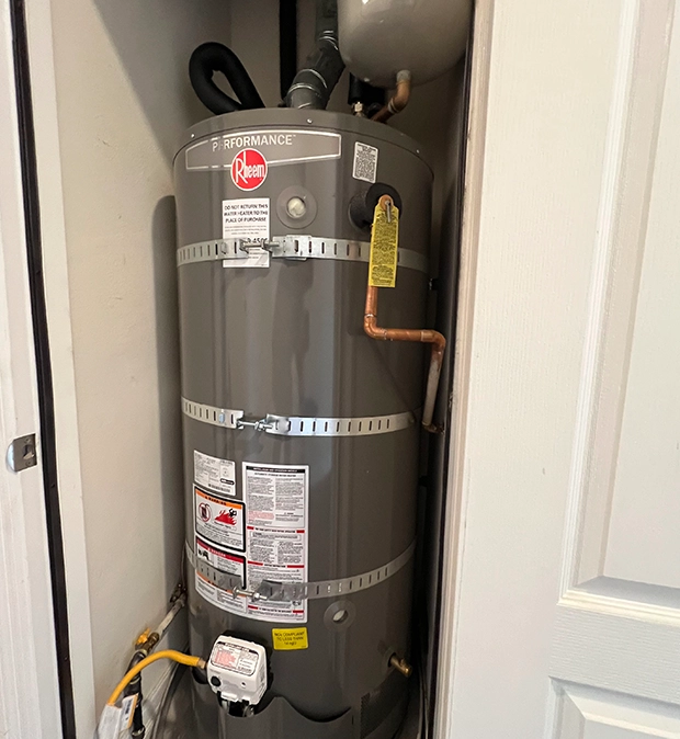 Close-up of plumber applying thread seal tape to a dripping pipe joint