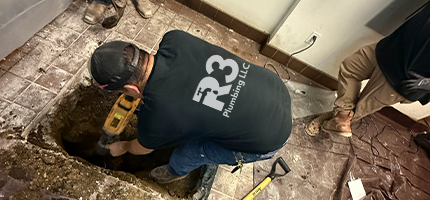 Two plumbers in uniforms discussing repair plans beside a service van