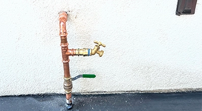 Assorted plumbing tools and copper pipes arranged on a wooden workbench surface